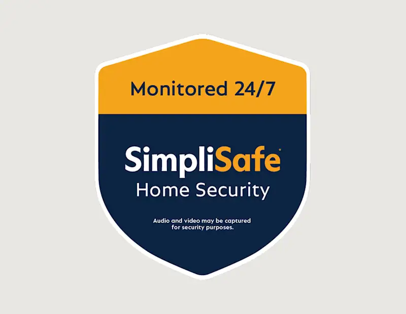SimpliSafe yard sign planted in a front lawn at dusk with a lit home in the background. Heading reads: 'Yard Sign.' Body text reads: 'Tell would-be intruders who's boss, keeping them away from your house. Sign and decals come free with your system.' Sign reads: 'Monitored 24/7 SimpliSafe Home Security.' Fine print on sign reads: 'Audio and video may be captured for security purposes.'