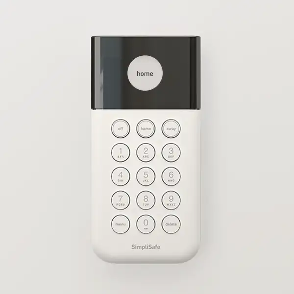 Hand pressing buttons on an illuminated SimpliSafe Keypad mounted on a wall. Heading reads: 'Keypad.' Body text reads: 'Arm and disarm your system. Panic Button built in. Place it by the front door, or anywhere you like.' Badge reads: 'Lights up in use.'