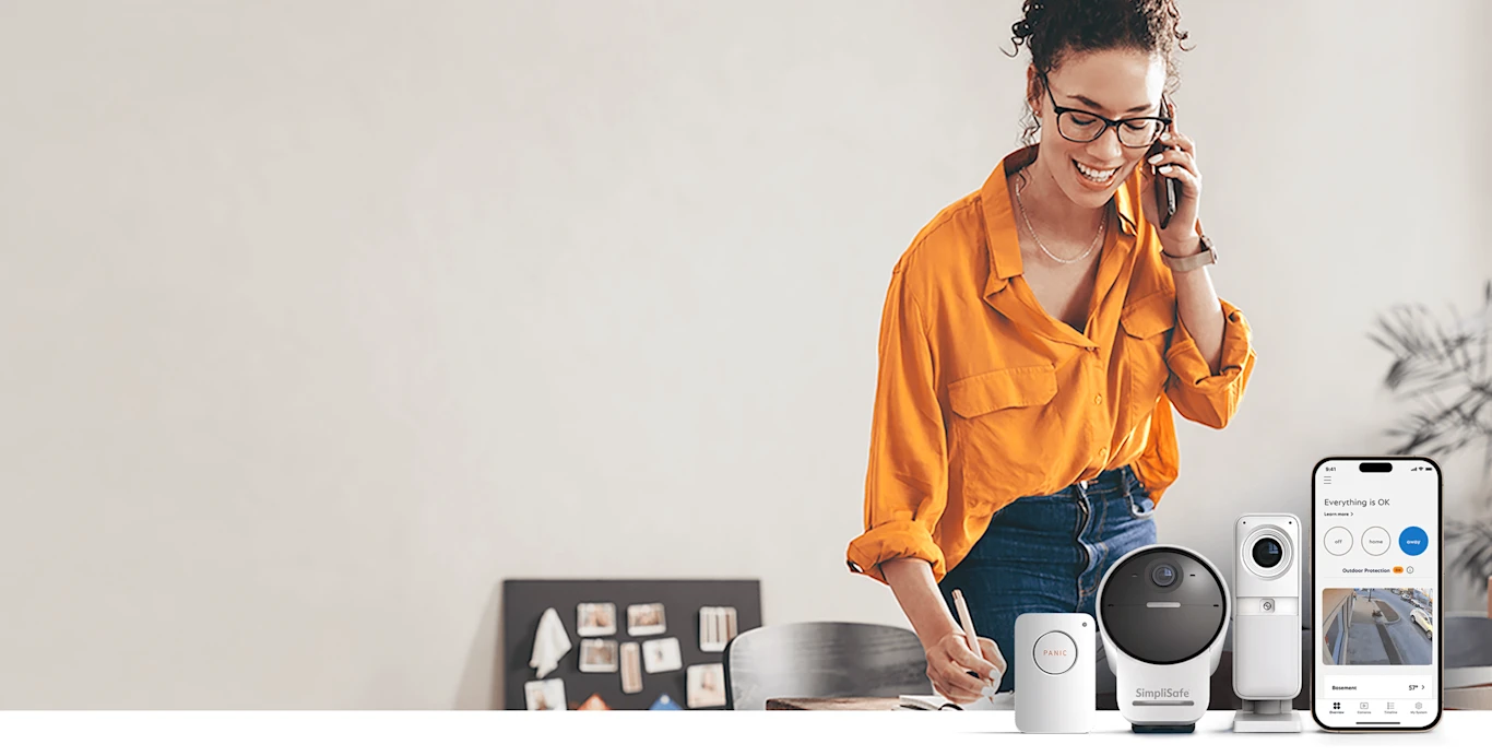 Image of woman with home security products, including a panic button, an outdoor camera, and an indoor camera