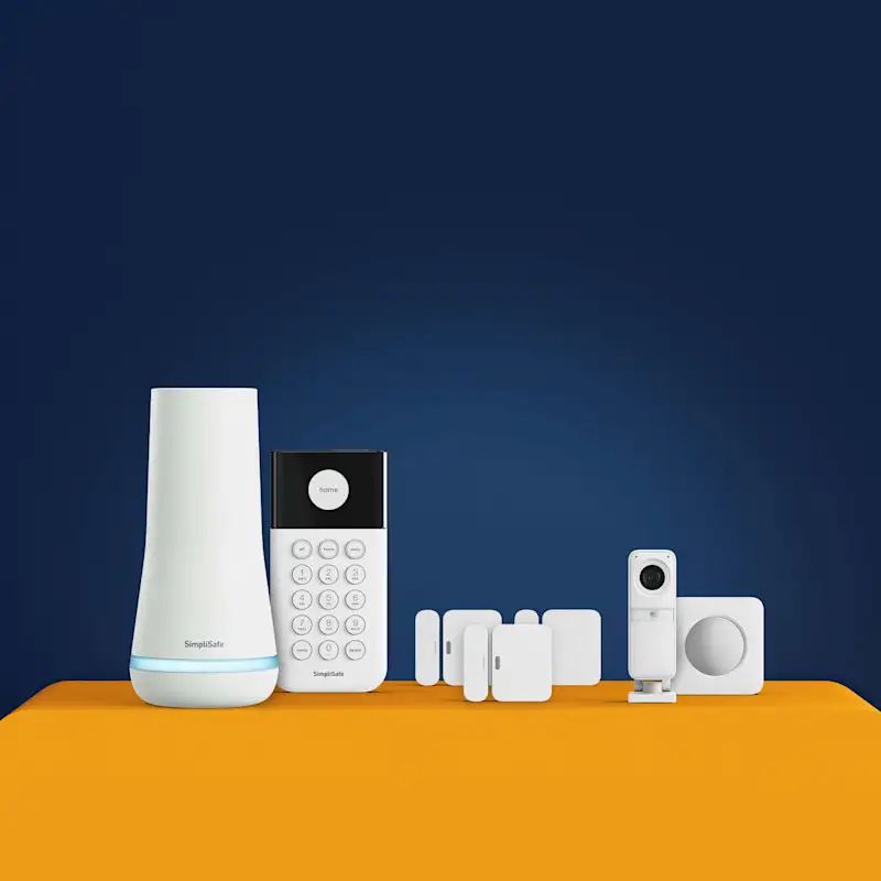 UK Package Essentials, showcasing a base station, motion detector, camera, and entry sensors.