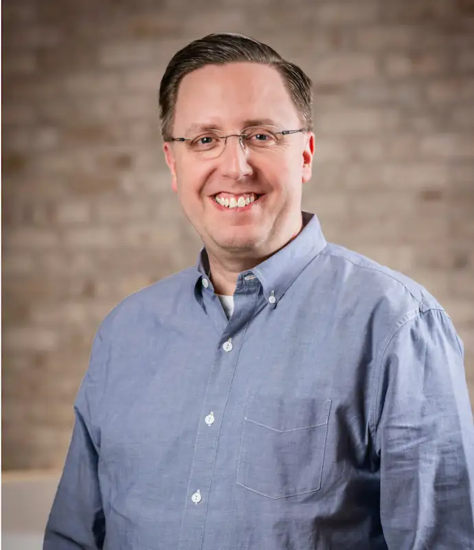 Don Nelson smiling and standing in an indoor setting.
