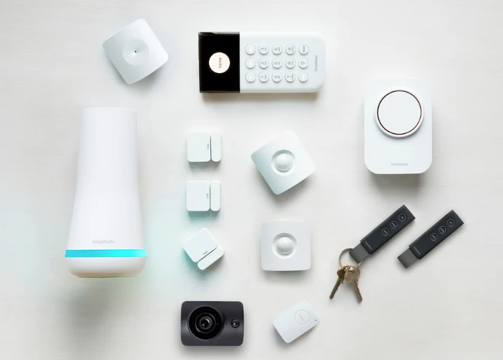 Image of a home security system laid out including a base station, keypad, siren, motion and entry sensors