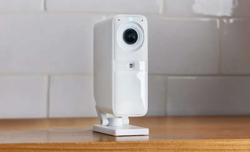 SimpliSafe Smart Alarm Indoor Camera on a wooden surface