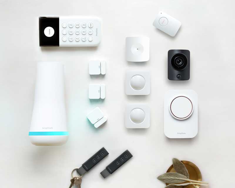 UK Package Essentials, showcasing a base station, entry sensors, glass break sensors, and a camera.