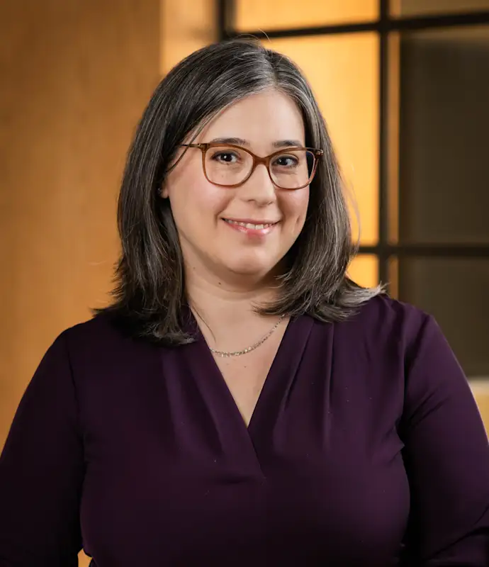 Rebecca Zavin smiling and standing in an indoor setting.