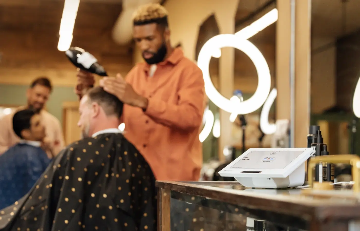 mini 3 on counter of barber shop owner while styling hair