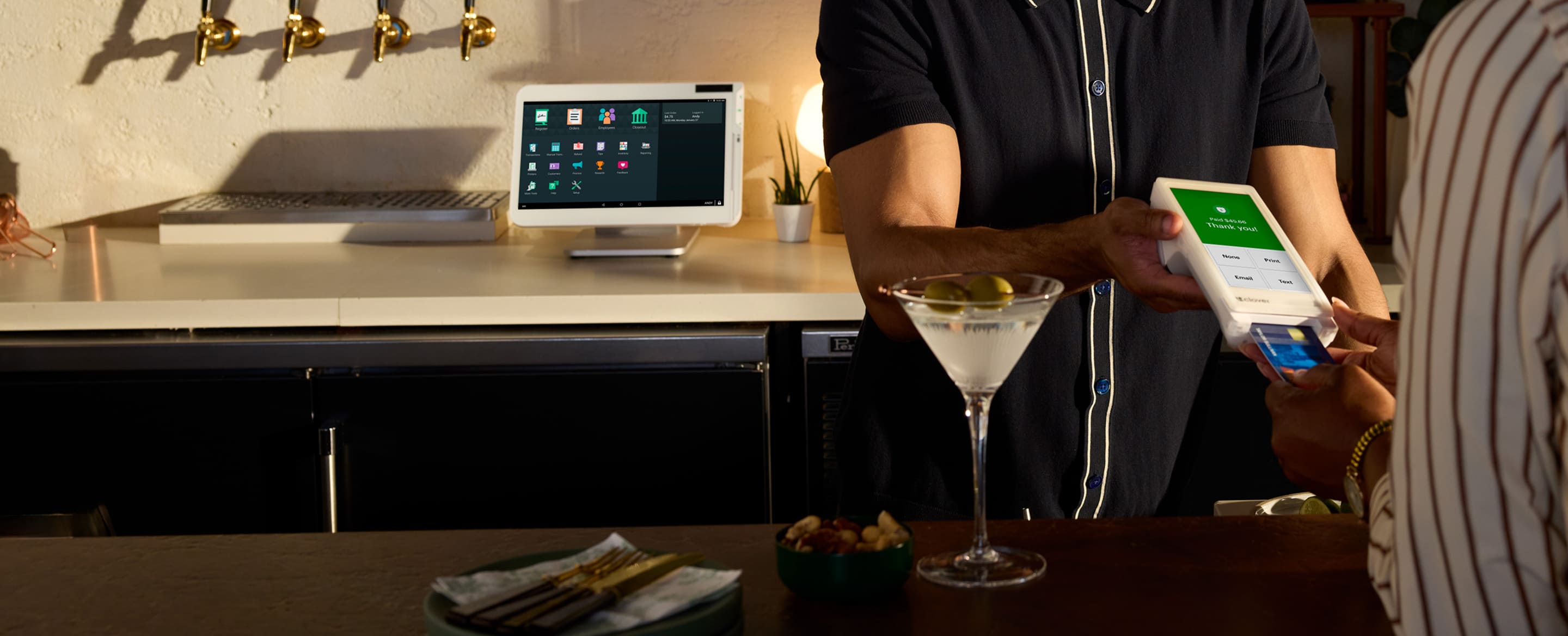Image displaying a bar lounge setup, and a customer is paying thru POS