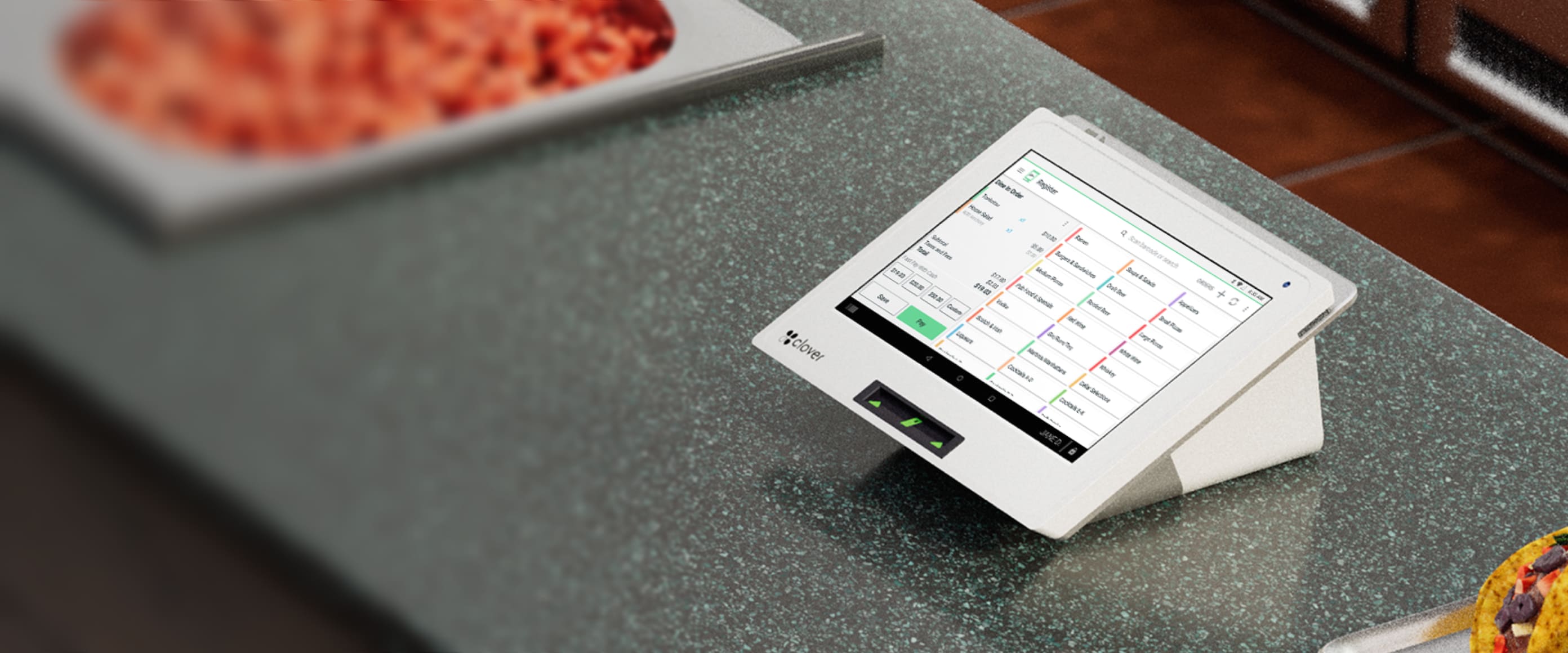 3D render of a Mini device placed on a counter next to diced tomatoes that is blurred out; taco in partial view.