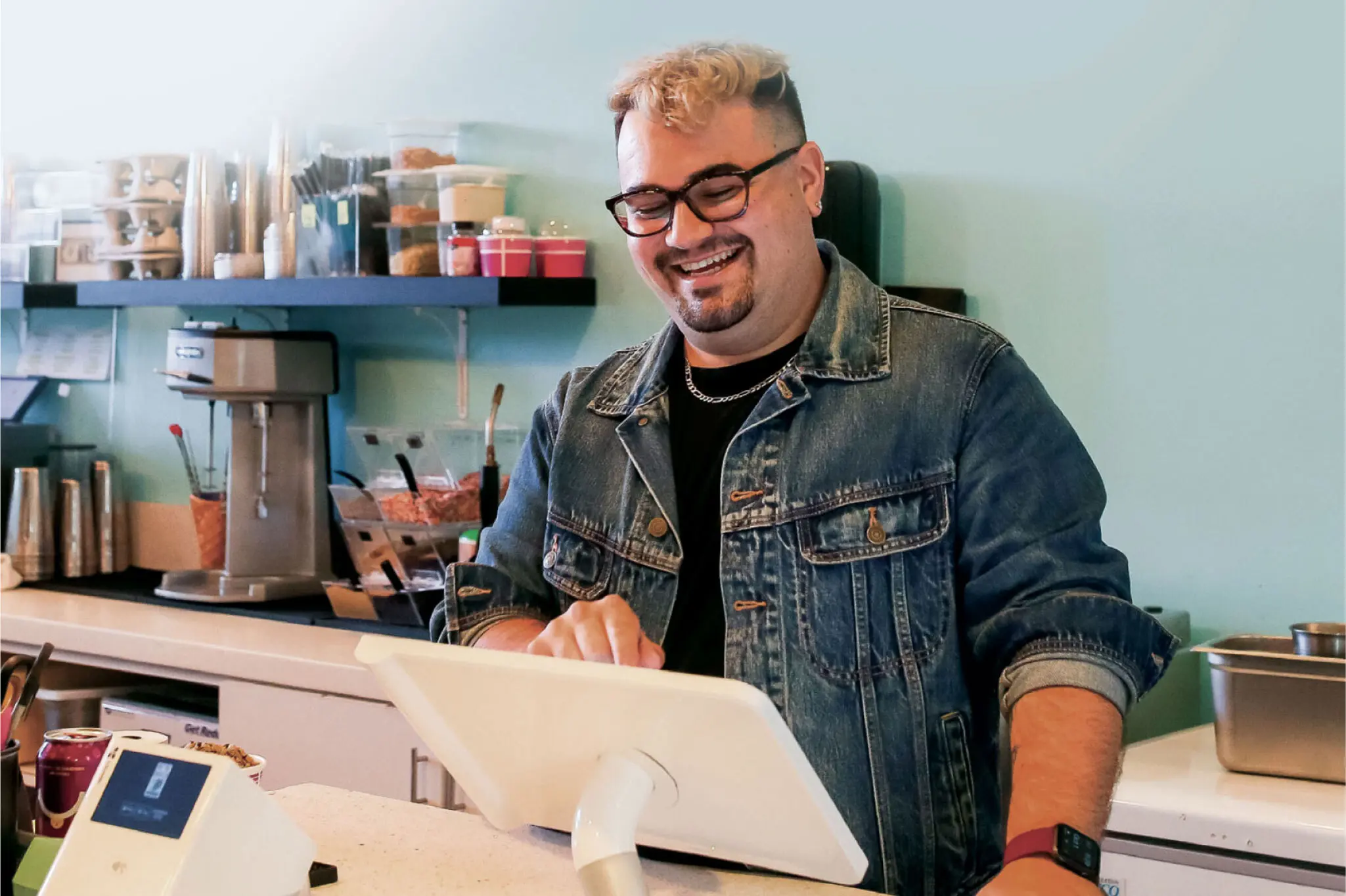 Merchant behind the counter at their dessert shop using a station solo device