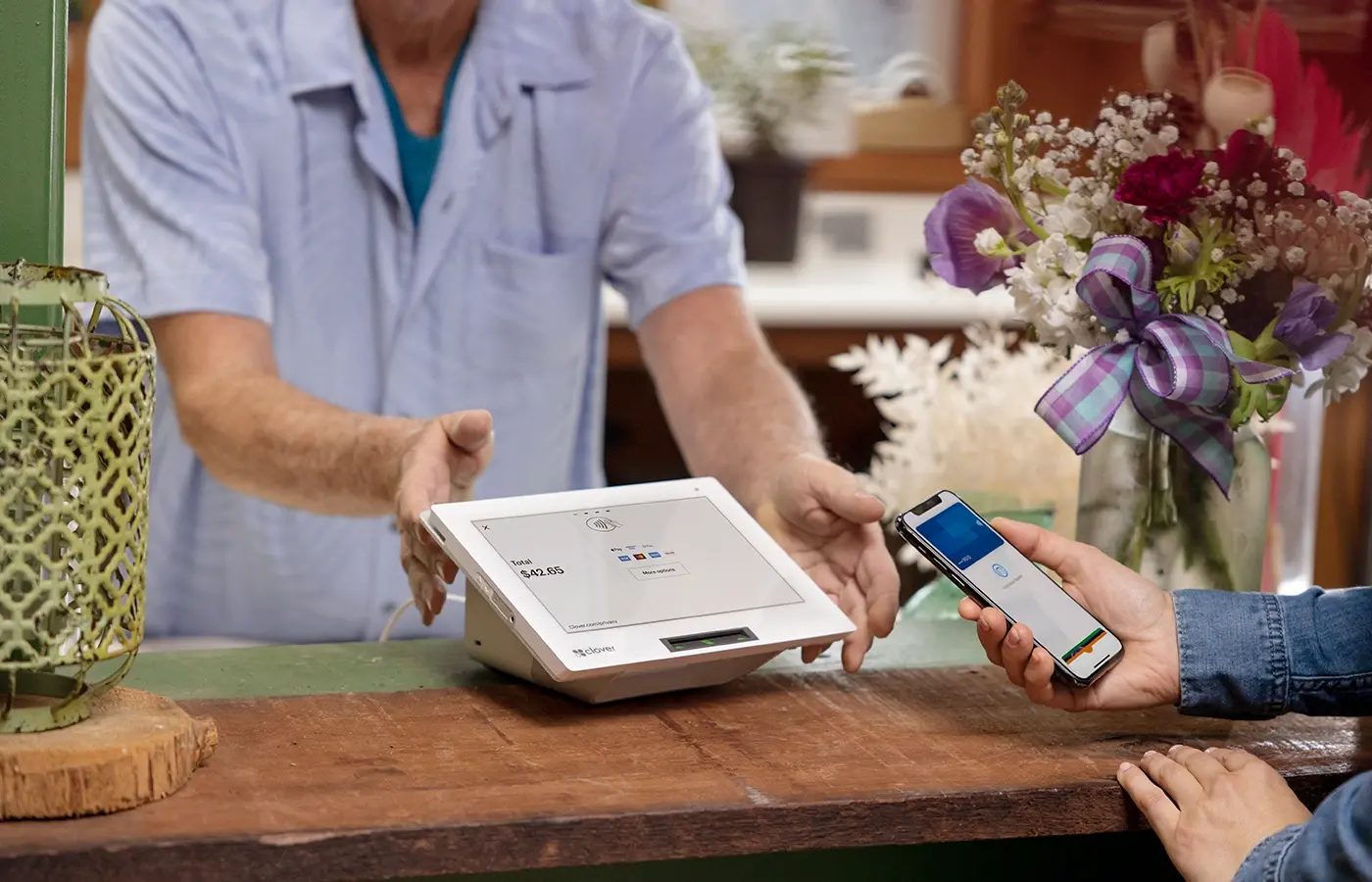 flower shop owner taking a customer payment with mobile tap to pay on a mini 3