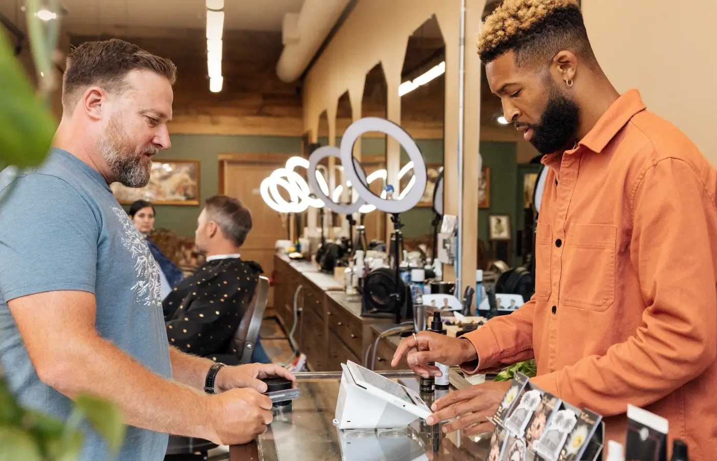 barber shop owner ringing up a customer on mini 3 screen