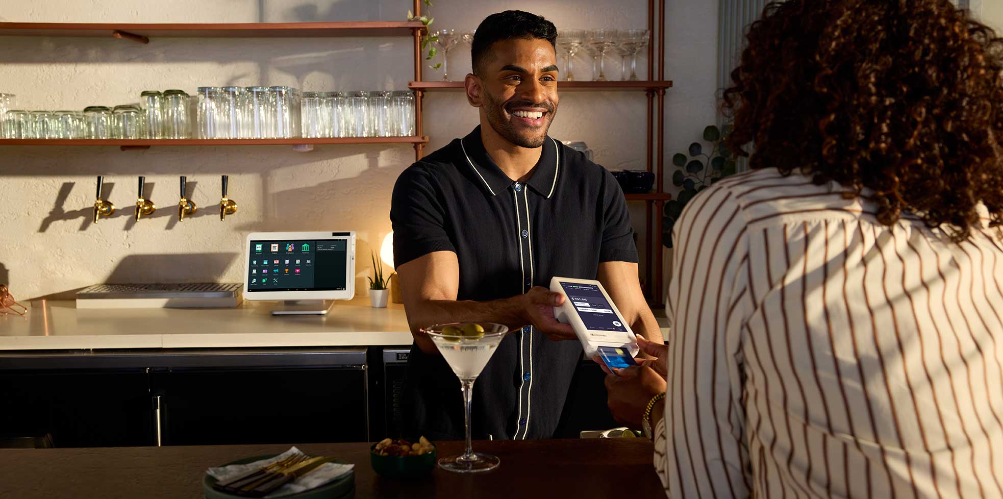 Customer makes a payment on a Clover Flex held by a bartender. 