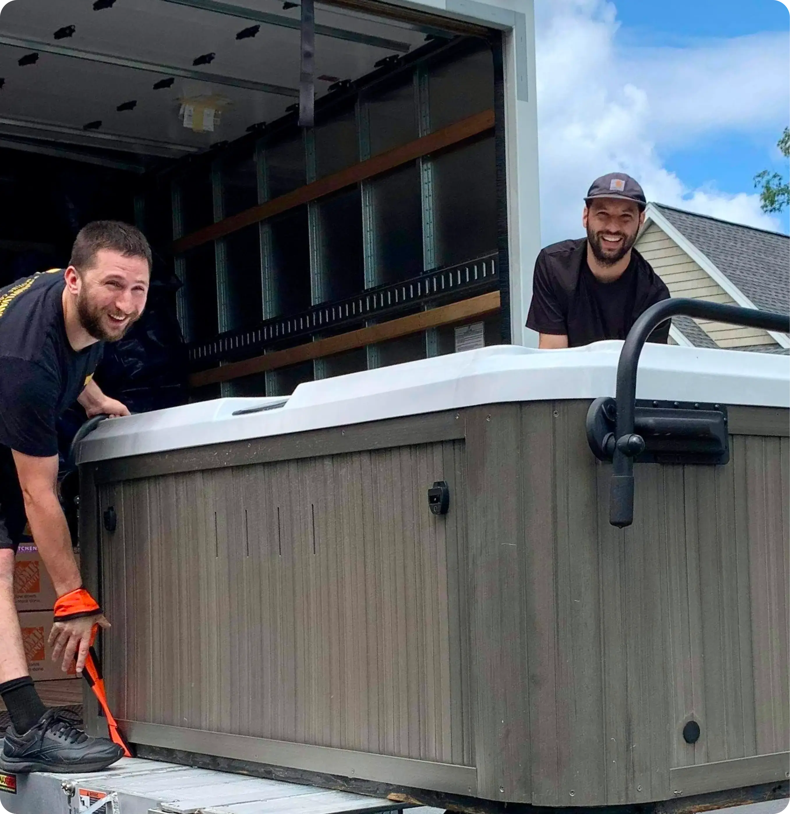 Two Transylvania moving company movers unloading a hot tub off the back of a truck