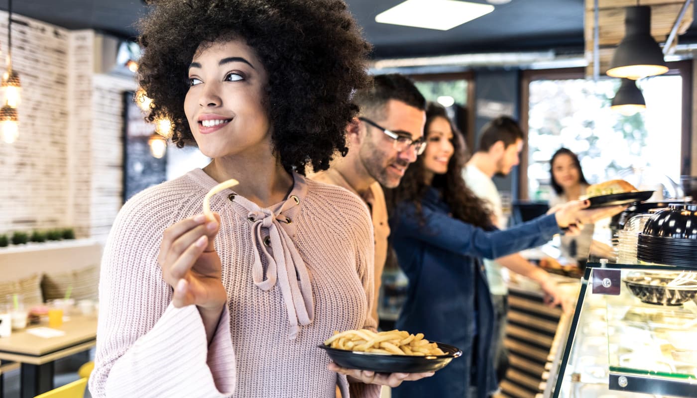 Woman holds a plate of french fries.