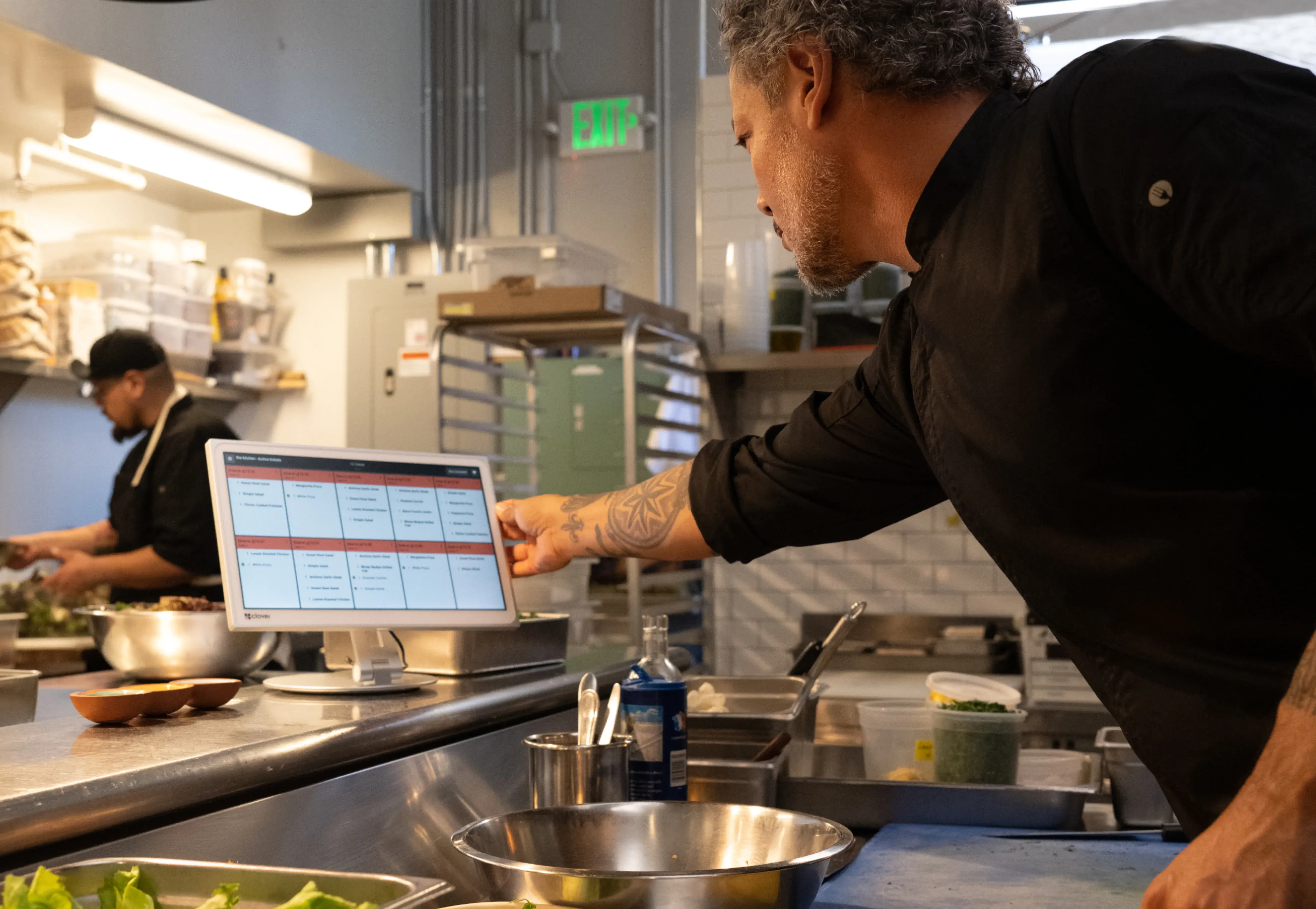 Chef touching screen of kitchen display system.