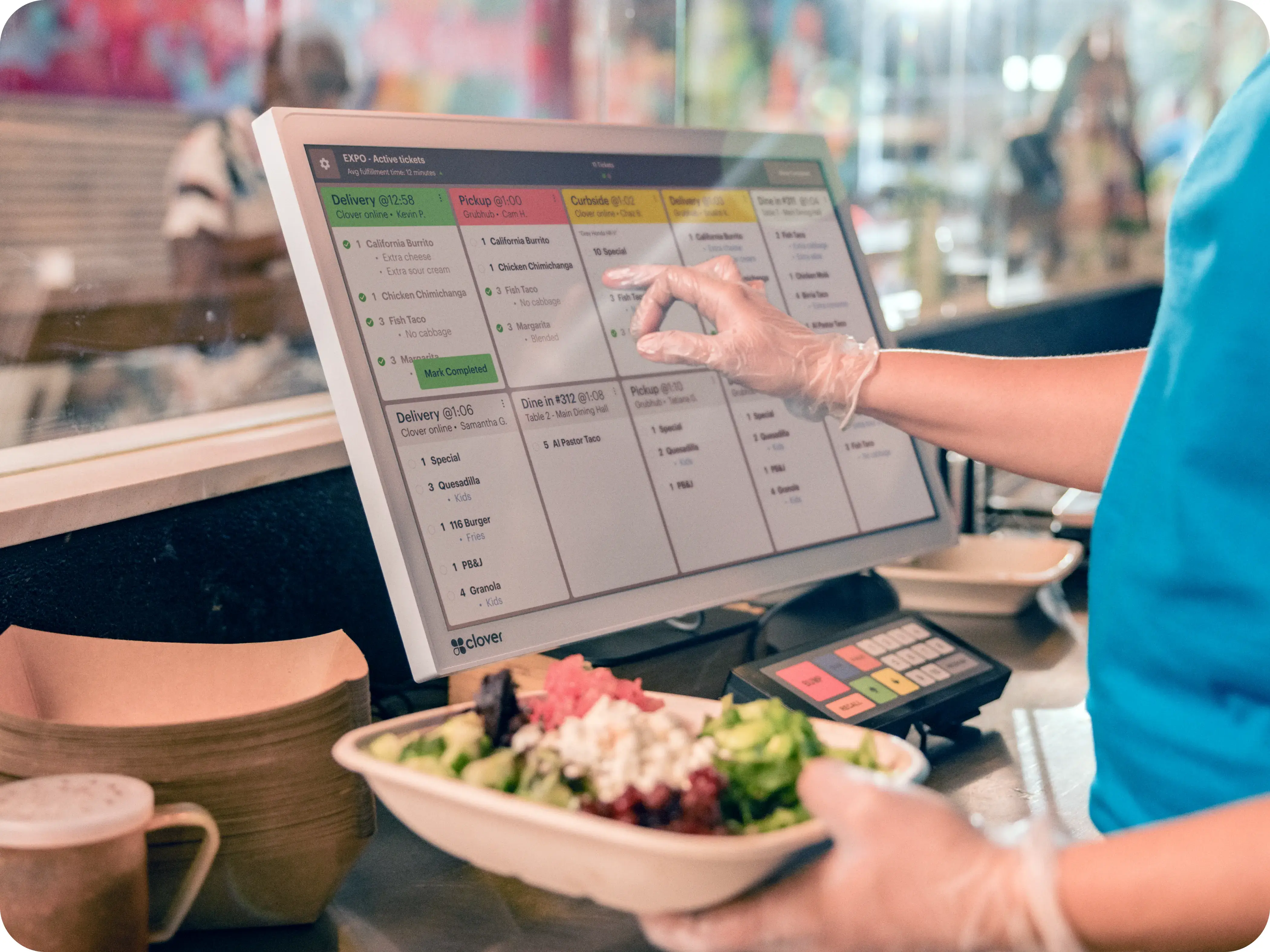 Chef holding bezel of kitchen display system while looking at orders.