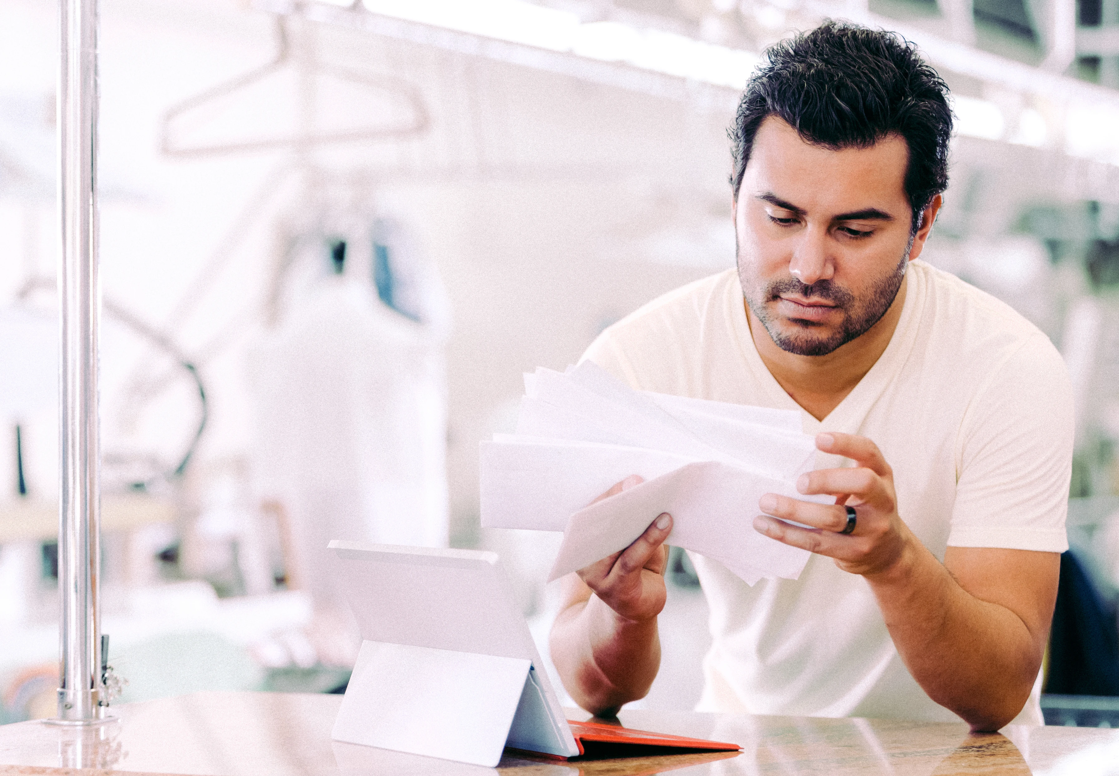 Dry cleaning business owner sorting through papers.