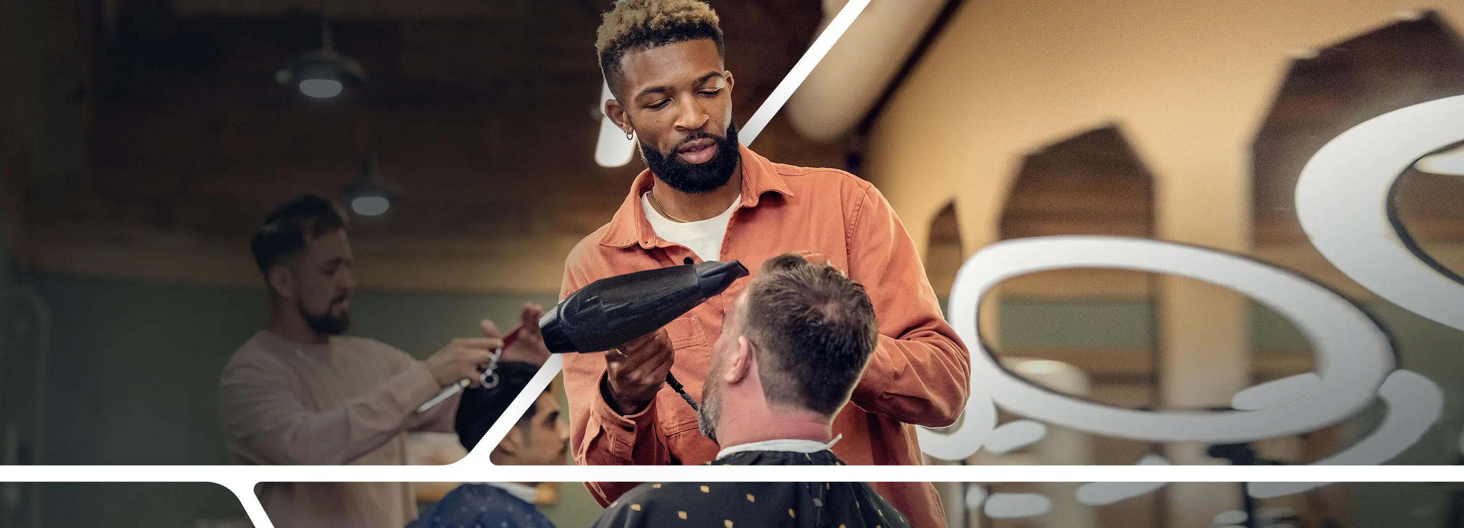 Barber blow drying a customer's hair. 