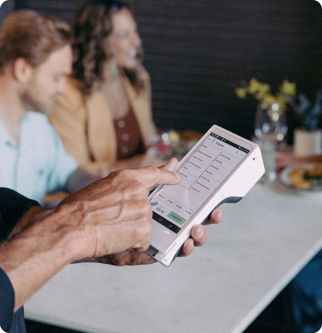 Server inputting a tableside order into a Clover Flex. 