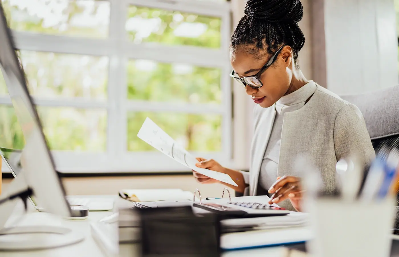 female accountant with calculator holding paperwork