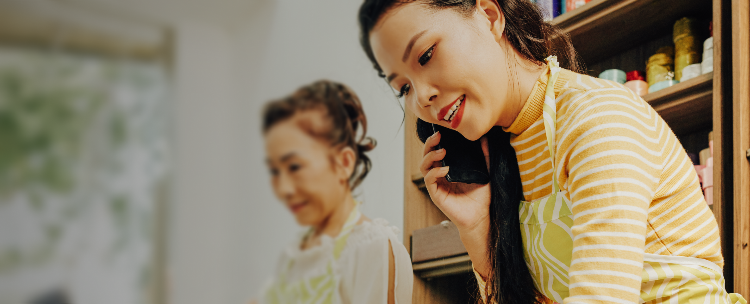 Woman on mobile phone writing something, we can see another woman in the background
