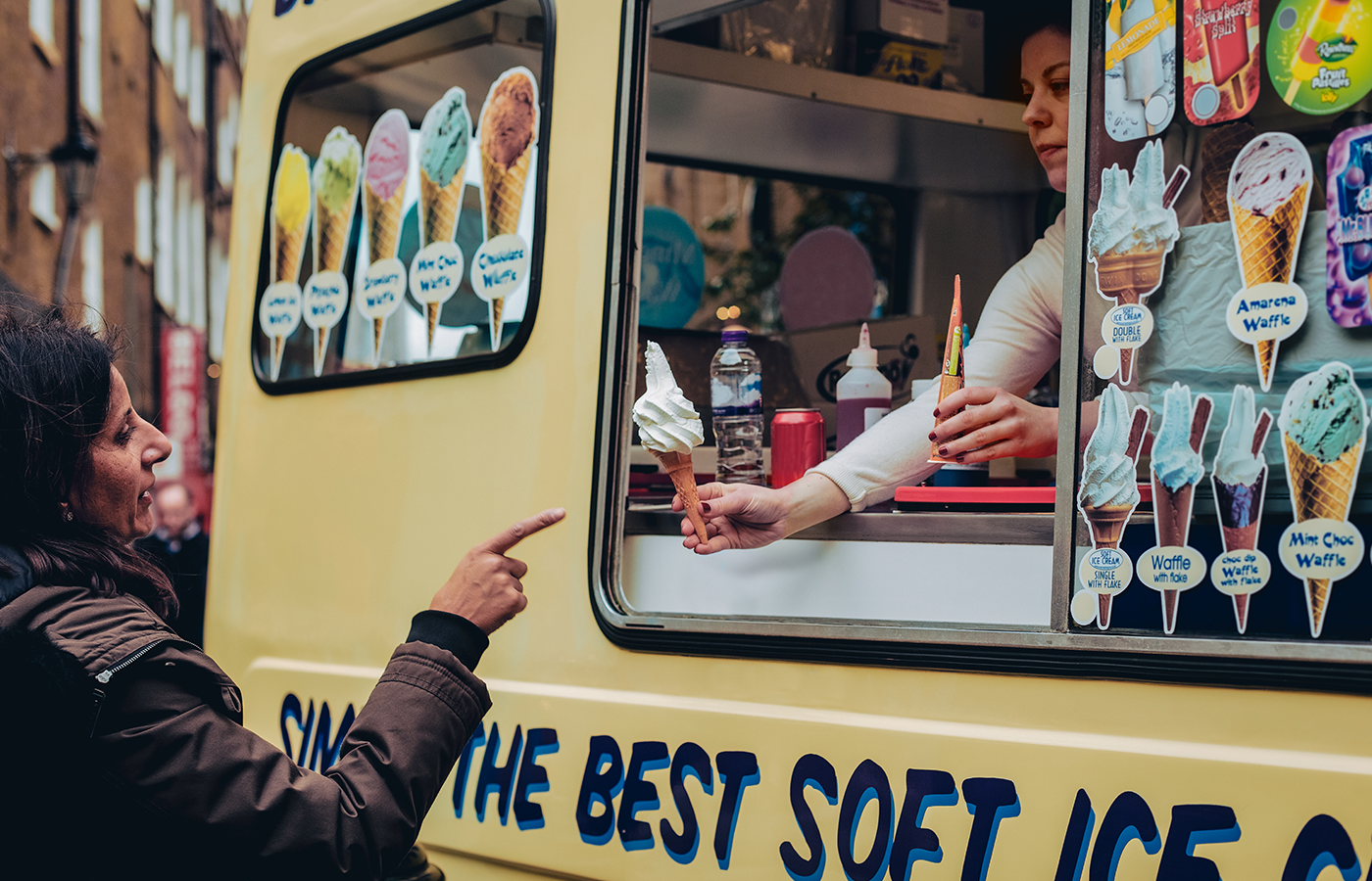 Woman purchases ice cream from an ice cream truck 