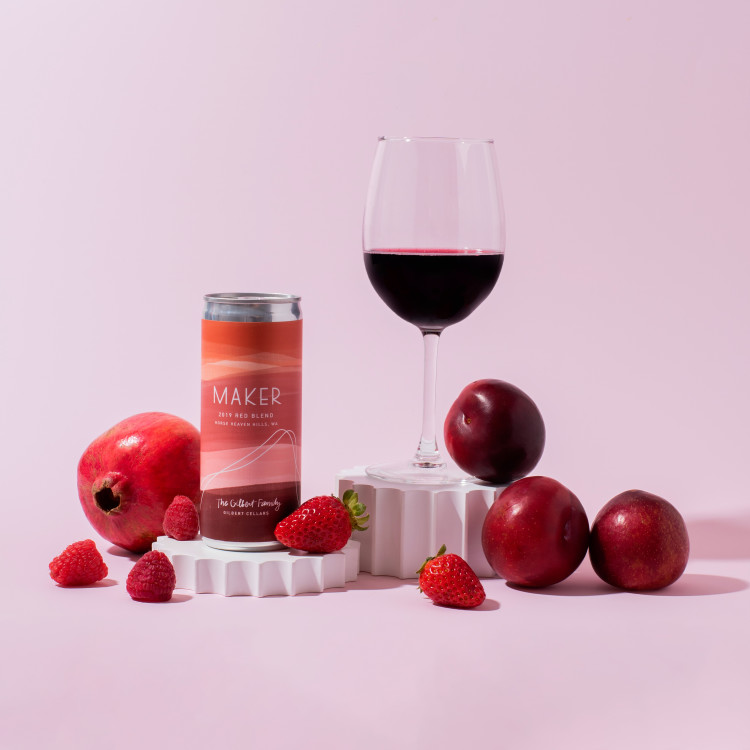 Red can of wine with glass of red wine and fruits around