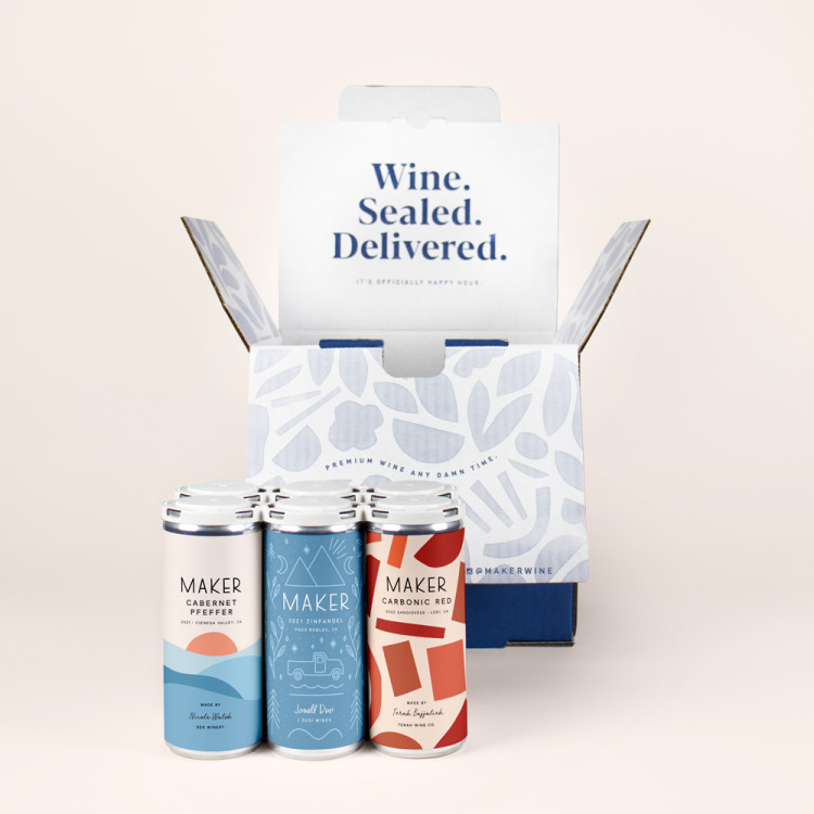 Six cans of Maker Wine in front of a blue shipper box.