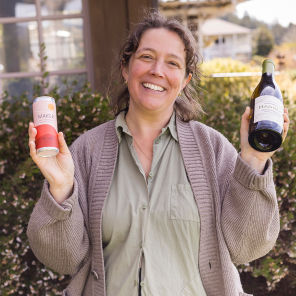 Lulu Handley holding a can and bottle of Pinot Noir.