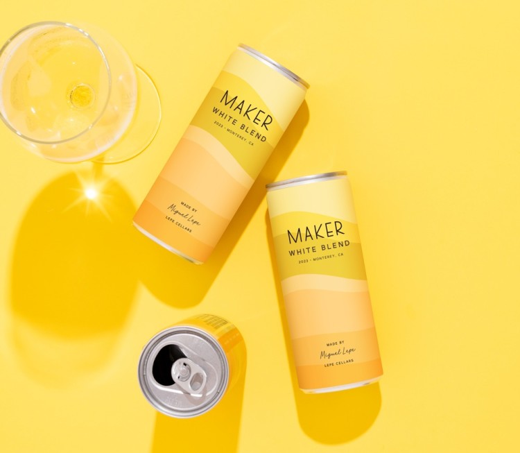 three cans of white blend on a yellow background with wine glass