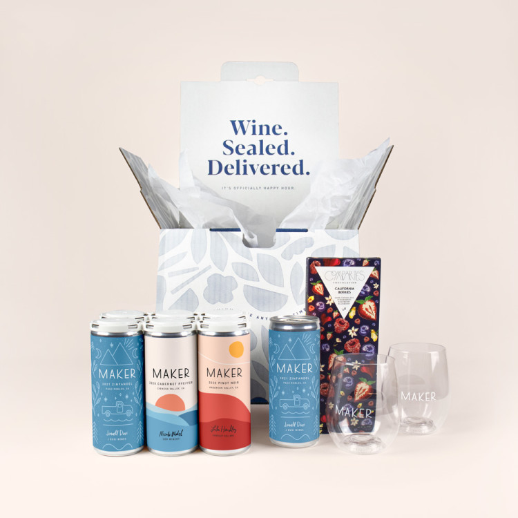 Six cans of Maker Wine alongside a bar of chocolate and two GoVino glasses, all in front of a blue shipper box.