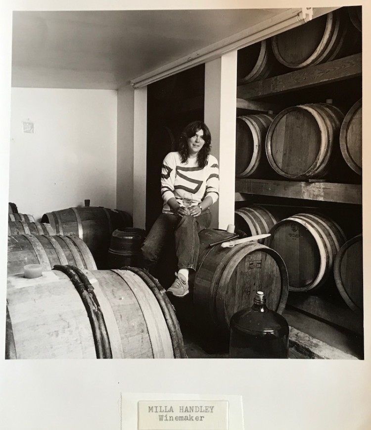 A photo of Milla Handley from the 1980s, sitting on a barrel of wine.