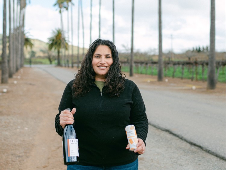 Terah Bajjalieh Terah Wine Co holding wine bottle and can of orange wine, photo by Alison Rae Photography 