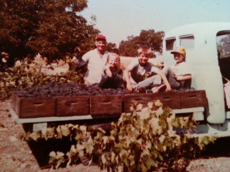 Janell Dusi and her siblings hauling grapes on her grandpa's blue tractor 