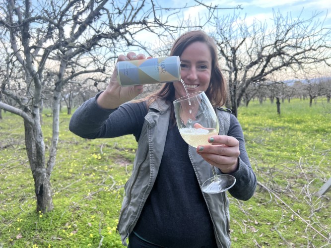 winemaker gianna pouring wine from can to glass in vineyard