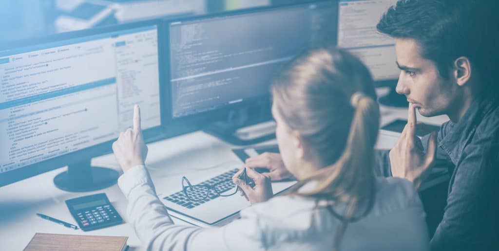 2 people going over software code on a screen