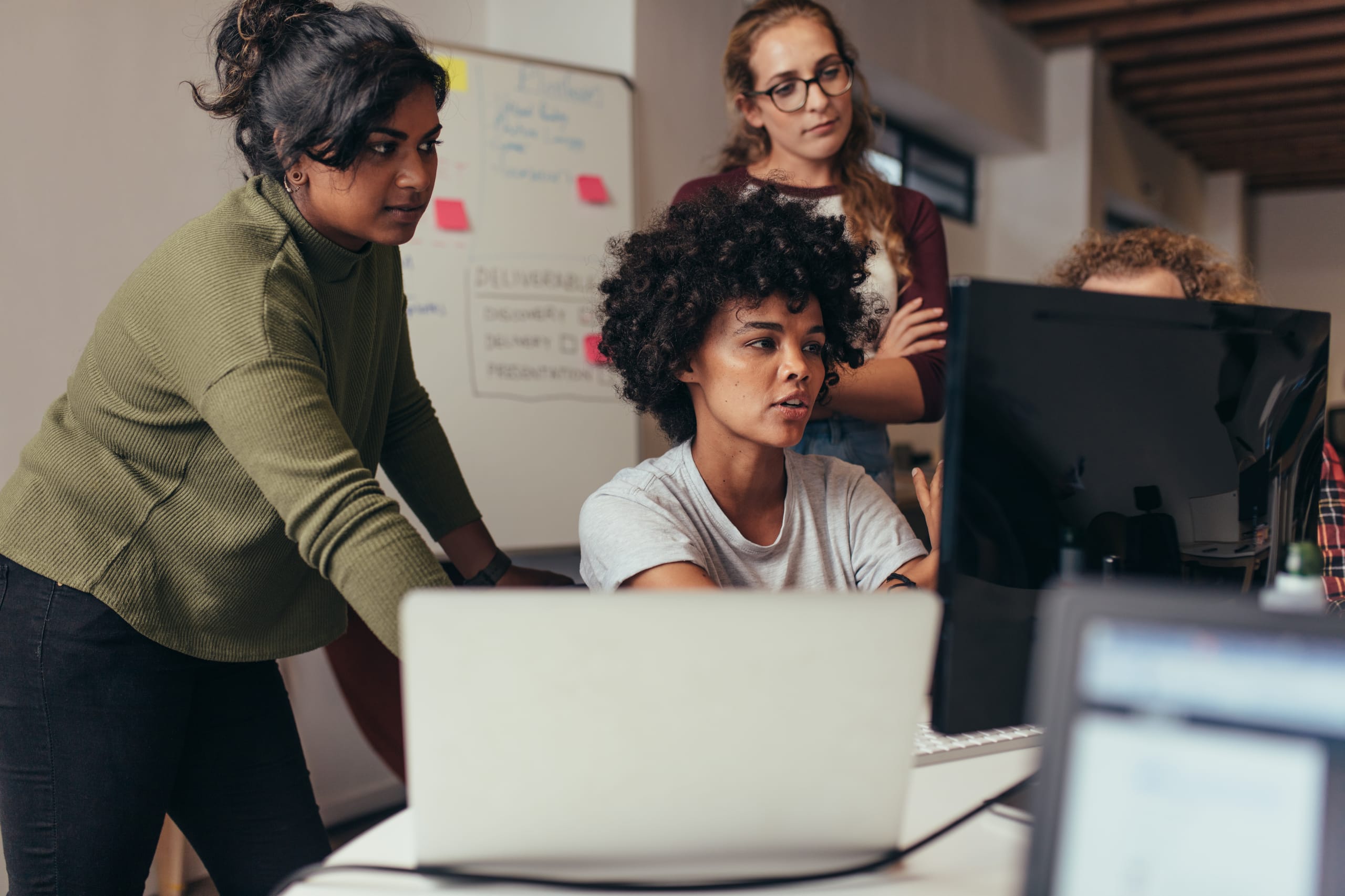 3 women working around a computer