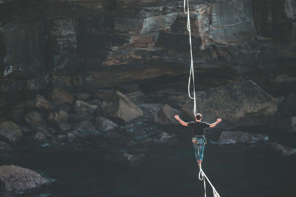 a man tightrope walking over a gorge