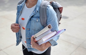 a girl with a backpack holding some books
