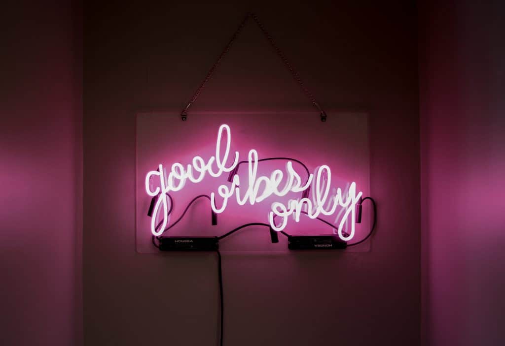 a pink neon sign saying "good vibes only"