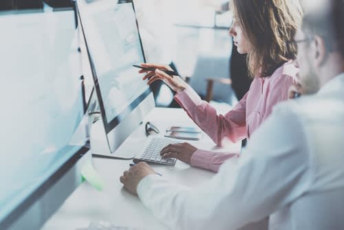 2 people studying a computer screen
