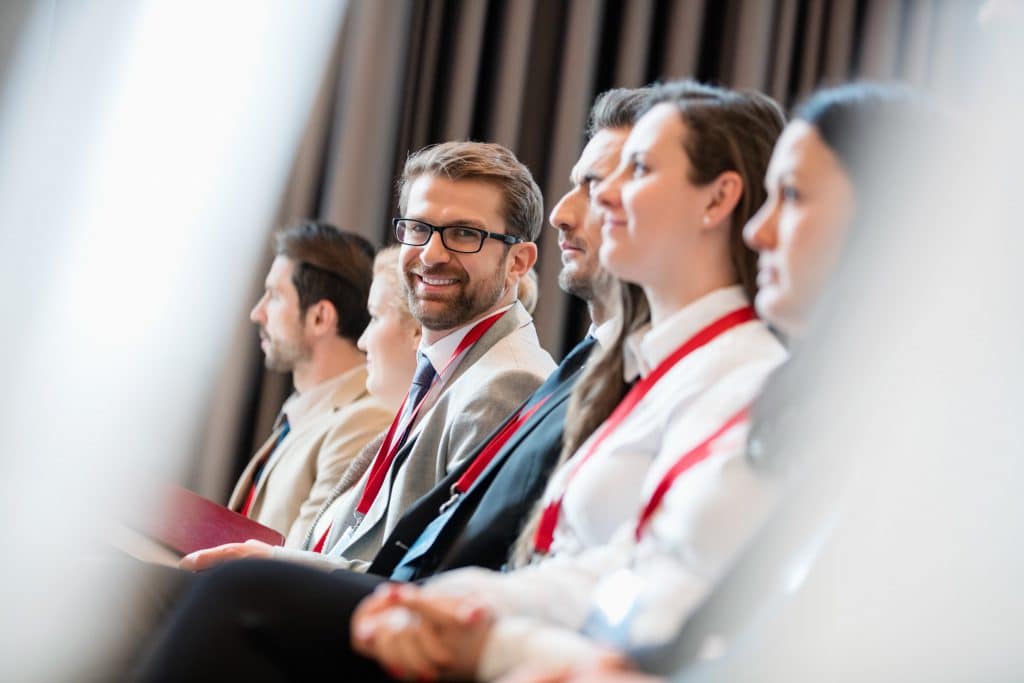 a group of people listening to a lecture