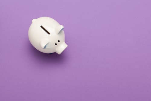 a white piggy bank on a purple surface