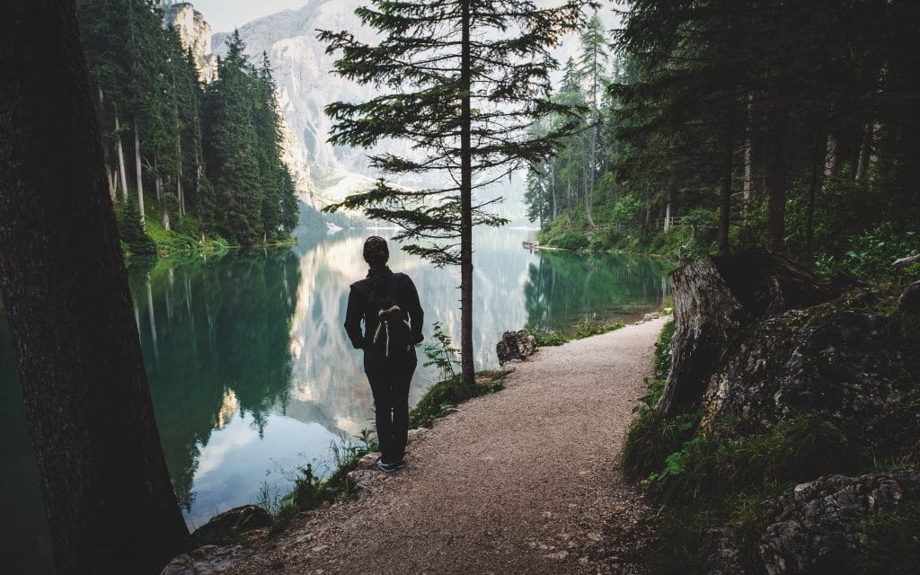 a woman on a hiking trail looking over a lake
