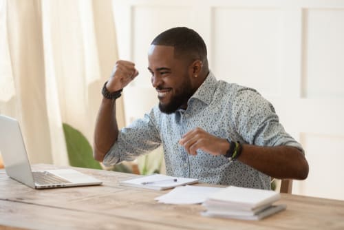 a person at a laptop celebrating a success