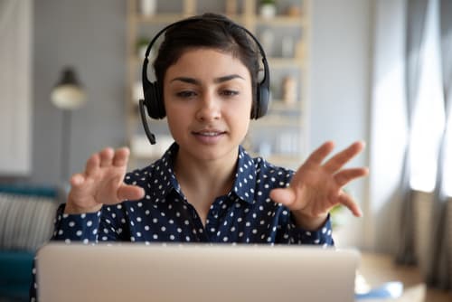 a woman working on a laptop with a headset