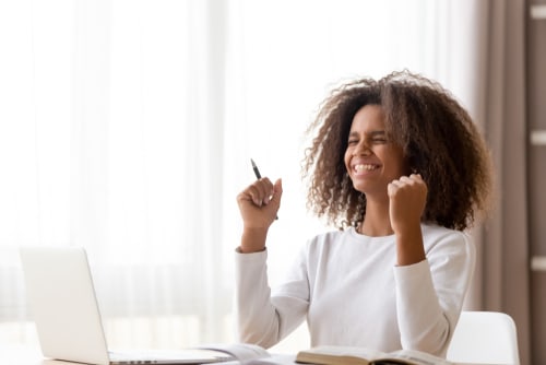 a woman at a desk looking very excited