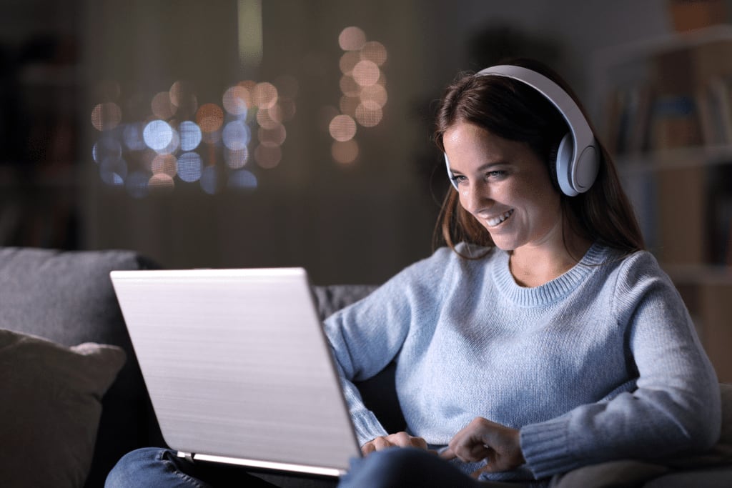 a girl sitting and watching content on a laptop