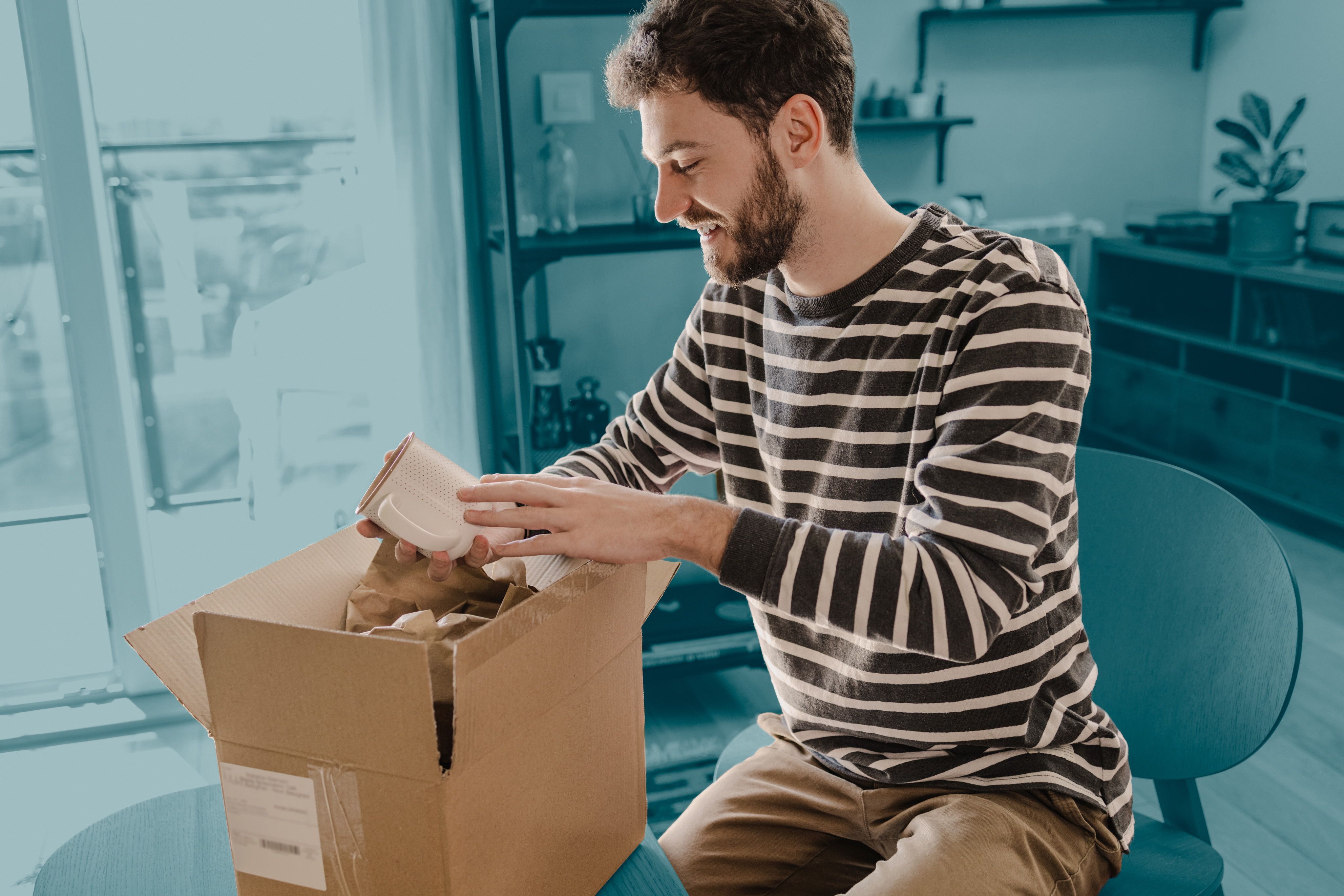 Man at home packing parcel