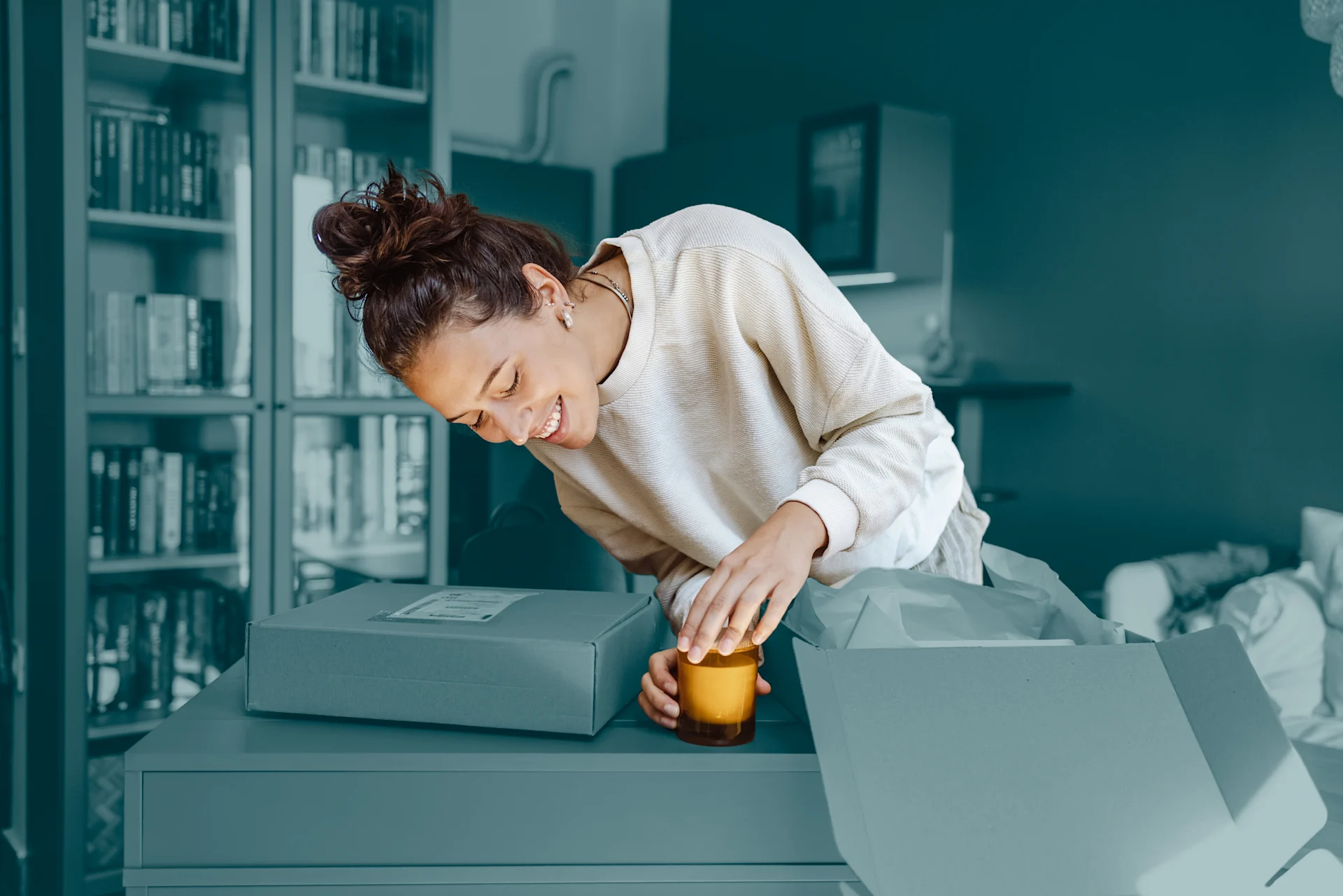 Woman preparing a yellow candle to ship, surrounded by parcel boxes